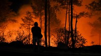 Warga berdiri di dekat lahan yang terbakar di Desa Simulop, Pangururan, Samosir, Sumatera Utara, Minggu (7/8/2022) malam.