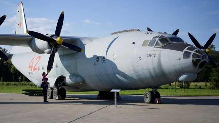 A girl sitting on her father's shoulders touches the propeller of an Antonov An-12 cargo aircraft at Patriot Park, a sort of military Disneyland outside Moscow aimed at showcasing Russia's military might, in the Moscow region on July 24, 2022. (Photo by Natalia KOLESNIKOVA / AFP) (Photo by NATALIA KOLESNIKOVA/AFP via Getty Images)
