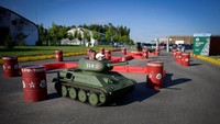 Seorang pria dan anak laki-laki mengendarai tank mainan di Patriot Park.