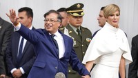 Presiden Kolombia Gustavo Petro melambaikan tangan saat tiba bersama istrinya Veronica Alcocer untuk upacara pengambilan sumpah di Bogota, Kolombia, Minggu (7/8/2022). Dilansir AFP, Senin (8/8/2022), Gustavo Petro merupakan mantan geriliyawan kiri berusia 62 tahun. Kemenangan Petro membawa Kolombia masuk dalam gelombang sayap kiri yang tengah meluas di Amerika LAtin. (Fernando Vergara/AP Photo)