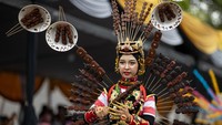 Beberapa tusuk sate yang menjadi hiasan punggung gadis berhijab ini. Terlihat sate tersebut seperti selesai dibakar.