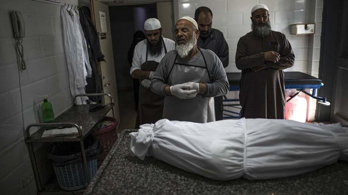 The body of Palestinian Muhammad Hassouna, who was killed in an Israeli airstrike is prepared for his funeral at a hospital in Rafah, in the southern Gaza Strip, Sunday, Aug. 7, 2022. An Israeli airstrike in Rafah killed a senior commander in the Palestinian militant group Islamic Jihad, authorities said Sunday, its second leader to be slain amid an escalating cross-border conflict. (AP Photo/Fatima Shbair)