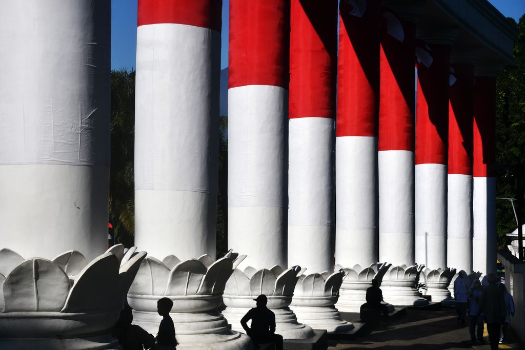 Warga berfoto dengan latar Lawang Salapan yang dibalut bendera Merah Putih di Kota Bogor, Jawa Barat, Senin (8/8/2022). Lawang Salapan yang merupakan ikon Kota Bogor tersebut dibalut dengan bendera Merah Putih sebagai bagian rangkaian kegiatan Festival Merah Putih dalam rangka menyambut HUT ke-77 Kemerdekaan Republik Indonesia. ANTARA FOTO/Arif Firmansyah/aww.