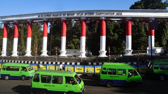 Warga berfoto dengan latar Lawang Salapan yang dibalut bendera Merah Putih di Kota Bogor, Jawa Barat, Senin (8/8/2022). Lawang Salapan yang merupakan ikon Kota Bogor tersebut dibalut dengan bendera Merah Putih sebagai bagian rangkaian kegiatan Festiv