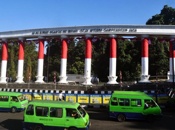 Warga berfoto dengan latar Lawang Salapan yang dibalut bendera Merah Putih di Kota Bogor, Jawa Barat, Senin (8/8/2022). Lawang Salapan yang merupakan ikon Kota Bogor tersebut dibalut dengan bendera Merah Putih sebagai bagian rangkaian kegiatan Festival Merah Putih dalam rangka menyambut HUT ke-77 Kemerdekaan Republik Indonesia. ANTARA FOTO/Arif Firmansyah/aww.