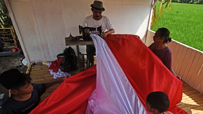 MENJAHIT BENDERA MERAH PUTIH RAKSASA Aktivis Organisasi Kepemudaan Patriot Bangsa Cabang Sukadiri dibantu anak-anak menjahit Bendera Merah Putih ukuran raksasa di Sukadiri, Kasemen, Serang, Banten, Senin (8/8/2022). Pembuatan Bendera Merah Putih dengan panjang 50 meter dan lebar 2,5 meter itu dalam rangka persiapan menyambut perayaan HUT Kemerdekaan RI ke-77 di area Cagar Budaya Kesultanan Banten. ANTARA FOTO/Asep Fathulrahman/aww.