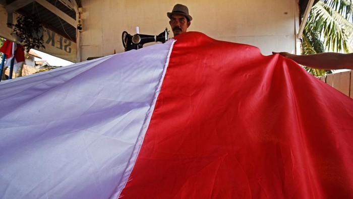 MENJAHIT BENDERA MERAH PUTIH RAKSASA Aktivis Organisasi Kepemudaan Patriot Bangsa Cabang Sukadiri dibantu anak-anak menjahit Bendera Merah Putih ukuran raksasa di Sukadiri, Kasemen, Serang, Banten, Senin (8/8/2022). Pembuatan Bendera Merah Putih dengan panjang 50 meter dan lebar 2,5 meter itu dalam rangka persiapan menyambut perayaan HUT Kemerdekaan RI ke-77 di area Cagar Budaya Kesultanan Banten. ANTARA FOTO/Asep Fathulrahman/aww.