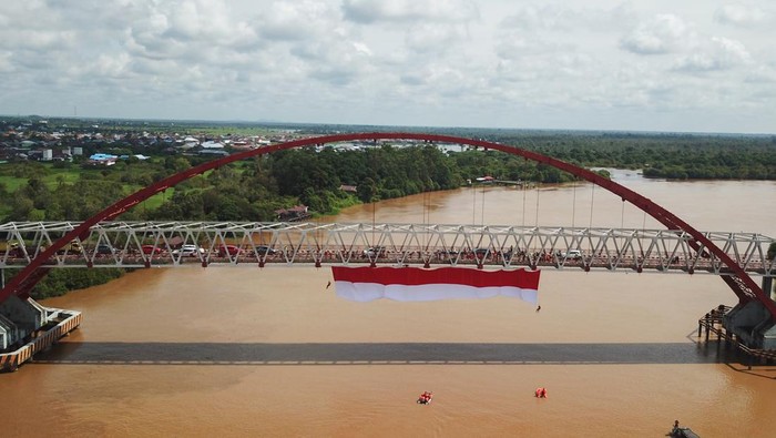 PEMBENTANGAN BENDERA MERAH PUTIH DI JEMBATAN KAHAYAN Foto udara sebuah bendera merah putih dibentangkan di Jembatan Kahayan, Palangka Raya, Kalimantan Tengah, Sabtu (6/8/2022). Aksi pembentangan bendera merah putih sepanjang 40 x 8 meter tersebut diikuti oleh TNI, Polri, Basarnas, BPBD, dan relawan ERP yang bertujuan untuk menumbuhkan rasa jiwa nasionalisme kepada generasi muda serta menyemarakkan HUT ke-77 Kemerdekaan Republik Indonesia. ANTARA FOTO/Makna Zaezar/nz