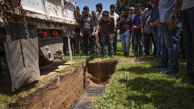Altaf Hussain menaburkan tanah di atas makam saudaranya Aftab Hussein di Fairview Memorial Park di Albuquerque, New Mexico, Jumat b(5/8/2022) Pemakaman diadakan untuk Aftab Hussein, 41, dan Muhammad Afzaal Hussain, 27, di Islamic Center of New Mexico pada hari Jumat. Kedua pria Muslim itu ditembak dan dibunuh di dekat rumah mereka hanya berselang enam hari. (Chancey Bush/The Albuquerque Journal via AP)