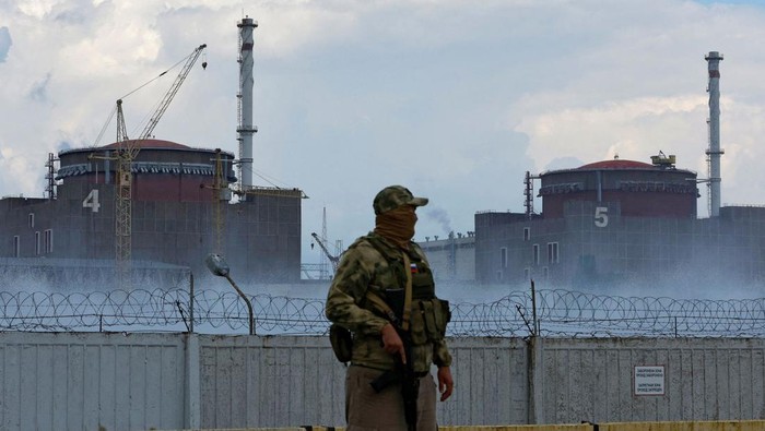 A serviceman with a Russian flag on his uniform stands guard near the Zaporizhzhia Nuclear Power Plant in the course of Ukraine-Russia conflict outside the Russian-controlled city of Enerhodar in the Zaporizhzhia region, Ukraine August 4, 2022. REUTERS/Alexander Ermochenko/File Photo