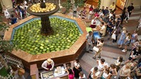 Para pengunjung mengantre es krim di samping kolam air yag dipenuhi semangka di pusat perbelanjaan GUM, Moskow, Rusia, Minggu (7/8/2022). Puncak musim panas membuat permintaan buah segar itu meningkat pesat.