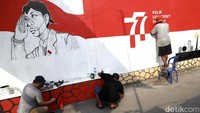 Warga di pemukiman Halim Perdanakusuma, Jakarta Timur, membuat mural guna menyambut HUT RI, Senin (08/08/2022).