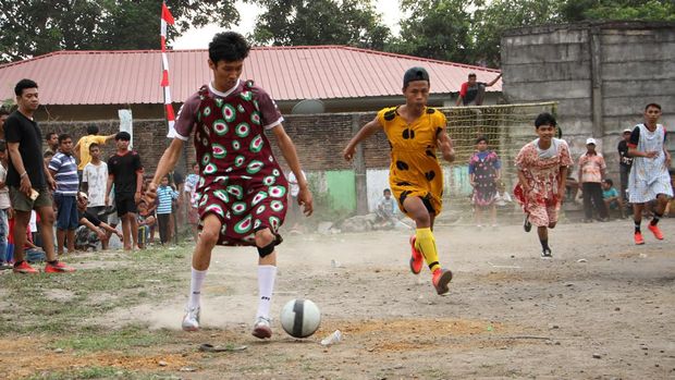 Sejumlah pemuda mengikuti pertandingan sepak bola dengan mengenakan daster di Makassar, Sulawesi Selatan, Minggu (7/8/2022). Warga setempat menggelar berbagai perlombaan untuk menyambut semarak HUT ke-77 Kemerdekaan Republik Indonesia. ANTARA FOTO/Arnas Padda/foc.
