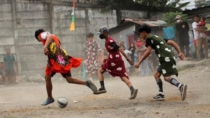 Sejumlah pemuda mengikuti pertandingan sepak bola dengan mengenakan daster di Makassar, Sulawesi Selatan, Minggu (7/8/2022). Warga setempat menggelar berbagai perlombaan untuk menyambut semarak HUT ke-77 Kemerdekaan Republik Indonesia. ANTARA FOTO/Arnas Padda/foc.