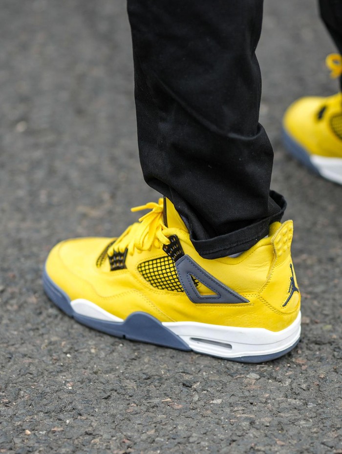 Sneakers Air Jordan PARIS, FRANCE - JUNE 22: A guest wears black denim pants, yellow shiny leather with gray details sneakers from Jordan, outside the Givenchy show, during Paris Fashion Week - Menswear Spring/Summer 2023, on June 22, 2022 in Paris, France. (Photo by Edward Berthelot/Getty Images)