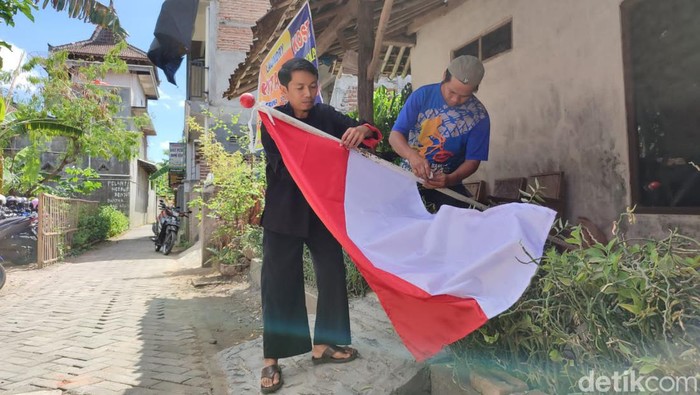 Tarmin membantu Bambang saat memasang bendera