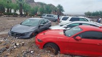 Penampakan mobil-mobil terjebak dan jalan rusak akibat material banjir.