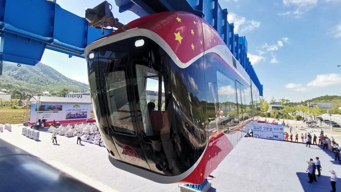 1413776911 XINGGUO, CHINA - AUGUST 09: Engineers take a selfie in front of China's first permanent maglev-suspension monorail, Xingguo, during a trial run on August 9, 2022 in Xingguo County, Ganzhou City, Jiangxi Province of China. The