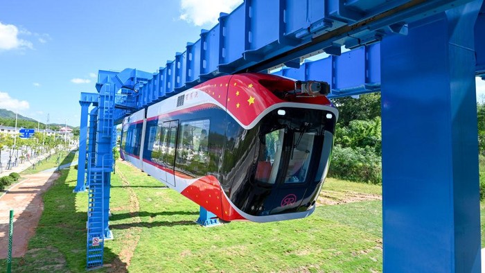 1413776911 XINGGUO, CHINA - AUGUST 09: Engineers take a selfie in front of China's first permanent maglev-suspension monorail, Xingguo, during a trial run on August 9, 2022 in Xingguo County, Ganzhou City, Jiangxi Province of China. The