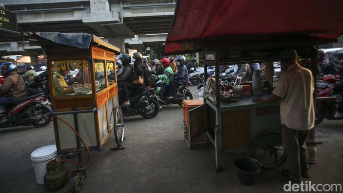 Kemacetan terjadi setiap pagi di Jalan Jakasampurna, Kota Bekasi. Meski jalan padat merayap, sejumlah PKL tetap berjualan di bahu jalan.