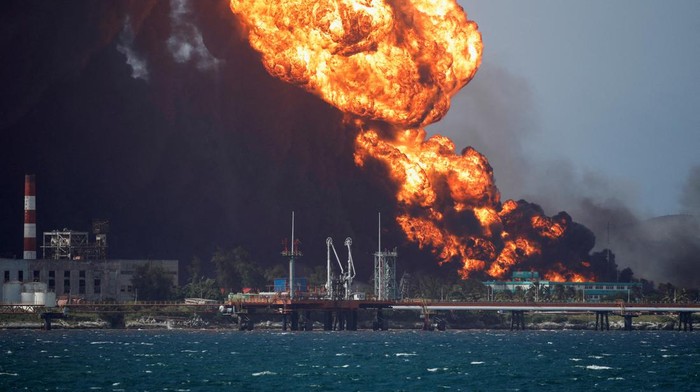 A lightning strikes through smoke from fuel storage tanks that exploded near Cuba's supertanker port in Matanzas, Cuba, August 8, 2022. REUTERS/Alexandre Meneghini