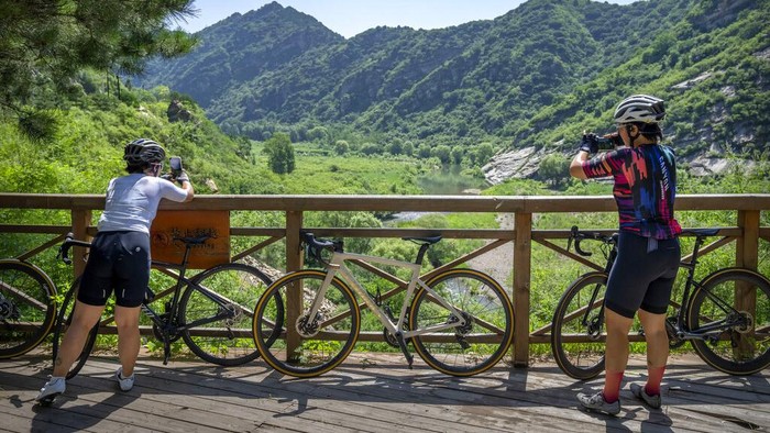 Members of the Qiyi bicycle club take a break at a mountain summit near the end of a group ride through the Baihe River Canyon in the northern outskirts of Beijing, Wednesday, July 13, 2022. Cycling has gained increasing popularity in China as a sport. A coronavirus outbreak that shut down indoor sports facilities in Beijing earlier this year encouraged people to try outdoor sports including cycling, which was only a major tool of transport before 2000. (AP Photo/Mark Schiefelbein)