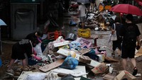 Warga mengevakuasi barang ke tempat yang tidak kebanjiran.  (AP Photo/Ahn Young-joon)