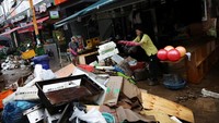Pedagang membereskan barang daganganya dari sisa banjir di Seoul. Selain itu, perjalanan kereta di Seoul dilaporkan turut mengalami delay karena banjir yang terjadi. (Kim Hong-Ji/Reuters)