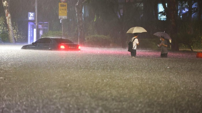 A vehicle is submerged in a flooded road in Seoul, Monday, Aug. 8, 2022. Heavy rains drenched South Koreas capital region, turning the streets of Seouls affluent Gangnam district into a river, leaving submerged vehicles and overwhelming public transport systems. (Hwang Kwang-mo/Yonhap via AP)