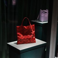 Di jajaran aksesori, tas Bao Bao menjadi salah satu kreasi ikonis Issey Miyake dengan bentuknya yang menyerupai susunan segitiga. Diperkenalkan pertama kali pada 2000, desain tas ini terus berevolusi mengikuti perkembangan zaman. (Foto: AFP via Getty Images/DANIEL LEAL)