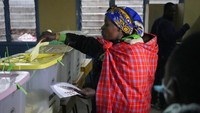 Seorang perempuan memasukkan kertas ke dalam bilik suara. (Khalil Senosi/AP Photo)