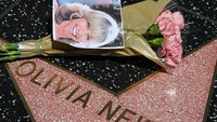 Para fans pada menaburkan bunga di ikon Hollywood Walk of Fame Olivia Newton-John. (Foto: ROBYN BECK/AFP via Getty Images)