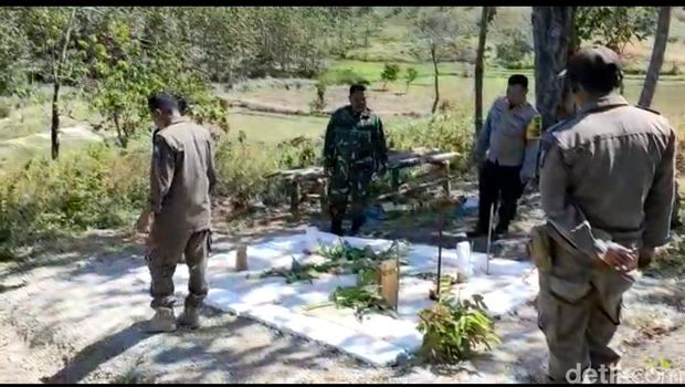 Petugas saat mengecek bangunan mirip makam di Bojonegoro