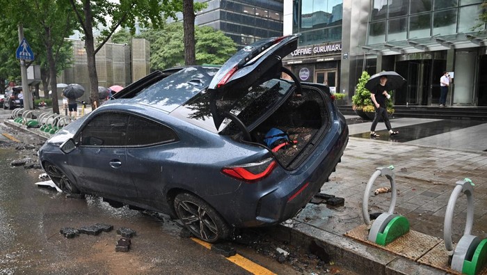 SEOUL, SOUTH KOREA - AUGUST 09: A vehicle is damaged on the sidewalk after floating in heavy rainfall on August 09, 2022 in Seoul, South Korea. The heaviest rainfall in 80 years has pounded Seoul and surrounding regions, leaving seven people dead and six others missing, as well as flooding homes, vehicles, buildings and subway stations, government officials said. (Photo by Chung Sung-Jun/Getty Images)