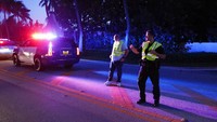 Polisi mengarahkan lalu lintas di luar pintu masuk ke perkebunan Mar-a-Lago mantan Presiden Donald Trump di Palm Beach, Florida, Amerika Sertikat, Senin (8/8/2022) waktu setempat. (AP Photo/Terry Renna)  