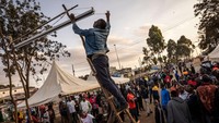 Warga memasang proyektor untuk menampilkan berita mengenai pemilu pada malam pemilihan presiden di pusat pemukiman informal Kibera pada Senin (8/8/2022) di Nairobi, Kenya.