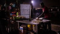 Seorang pria membuat chapati di sebuah kafe pada malam pemilihan presiden di pusat pemukiman informal Kibera.
