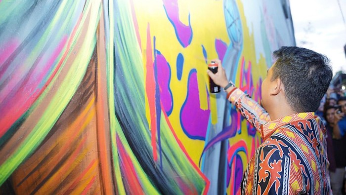 Bobby saat ikut membuat mural di Kota Padang