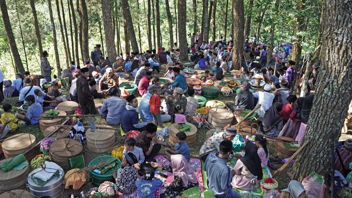 Bukan Piknik, Mereka Lagi Nyadran di Bawah Pohon Pinus, Lihat Nih Keakrabannya Sejumlah warga berdoa saat mengikuti tradisi Nyadran Kyai Kramat di kawasan hutan Pinus Desa Tlogopucang, Kandangan, Temanggung, Jawa Tengah, Selasa (9/8/2022). Tradisi Nyadran rutin dilaksanakan masyarakat petani kopi setempat setiap tanggal 11 bulan Suro yang bertujuan untuk mengirim doa kepada arwah leluhur sekaligus ungkapan rasa syukur dan permohonan doa kepada Tuhan YME. ANTARA FOTO/Anis Efizudin/aww.