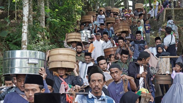 Warga membawa Tenong berisi berbagai jenis makanan dan nasi tumpeng saat tradisi Nyadran Kyai Kramat di kawasan hutan Pinus Desa Tlogopucang, Kandangan, Temanggung, Jawa Tengah, Selasa (9/8/2022).   