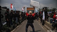 Massa memblokade mobil yang melintas.