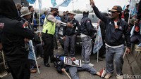 Polisi meminta massa buruh minggir agar pengendara dapat melintas.