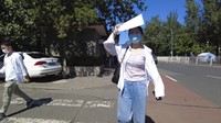 Liu Qian berjalan sambil membawa beberapa dokumen untuk melamar pekerjaan di Ibu Kota Beijing, Kamis (7/8/2022). 