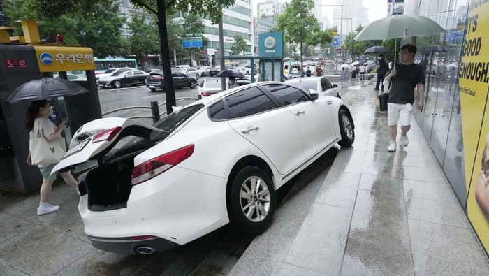 A vehicle is damaged on the sidewalk after floating in heavy rainfall in Seoul, South Korea, Tuesday, Aug. 9, 2022. Heavy rains drenched South Korea's capital region, turning the streets of Seoul's affluent Gangnam district into a river, leaving submerged vehicles and overwhelming public transport systems. (AP Photo/Ahn Young-joon)