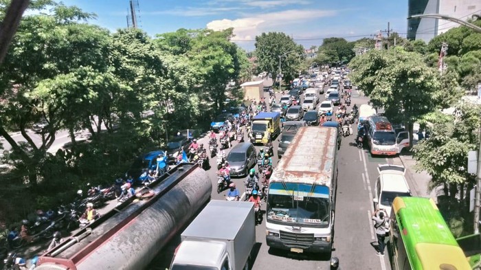 Frontage Jalan Ahmad Yani merambat gegara kedatangan ratusan buruh yang akan melakukan aksi di depan DPRD Jatim.