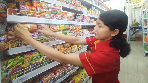 Salah satu pegawai di salah satu minimarker tampak merapikan stok mie instan pada Rabu (10/6/2022)