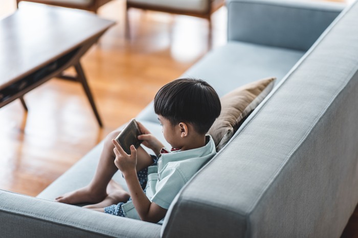 Chinese boy using smart phone in the living room