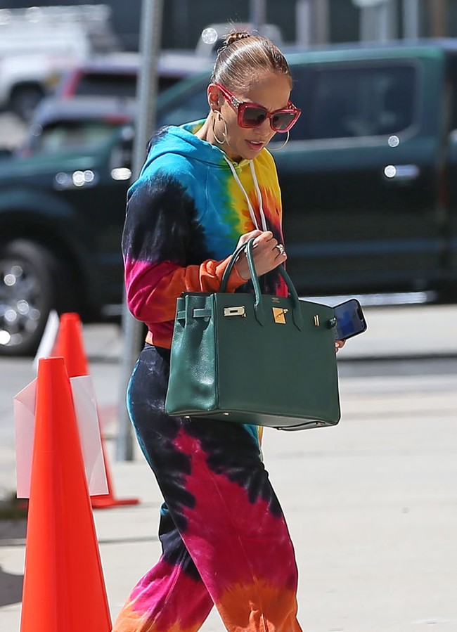 Ibu dua anak ini memadukan gaya warna-warninya dengan sneakers putih dan tas Hermes Birkin hijau. Foto: Getty Images