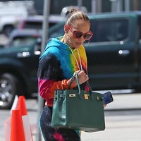 Ibu dua anak ini memadukan gaya warna-warninya dengan sneakers putih dan tas Hermes Birkin hijau. Foto: Getty Images