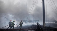 Petugas pemadam kebakaran bekerja di zona di mana tangki penyimpanan bahan bakar meledak di dekat pelabuhan supertanker Kuba di Matanzas, Kuba, Selasa, (9/8/2022). Minyak mentah berat Kuba, serta bahan bakar minyak dan solar yang disimpan di Matanza dalam 10 tangki besar. Sebagian besar digunakan untuk menghasilkan listrik di pulau itu.